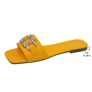 Detailed view of yellow flat slide sandal featuring a 1cm heel height and crystal buckle.