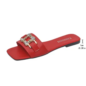 Close-up detail of red flat slide sandal with crystal buckle and 1cm heel height