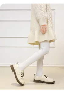 Nahaufnahme von cremefarbenen Lederschuhen für Mädchen mit genähten Herzmustern.