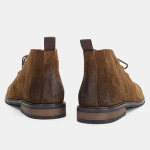 Vue arrière de bottines désert en daim marron avec talons polis et languettes arrière