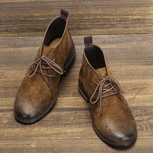 Détail de bottines desert en daim marron vintage sur un sol en bois rustique