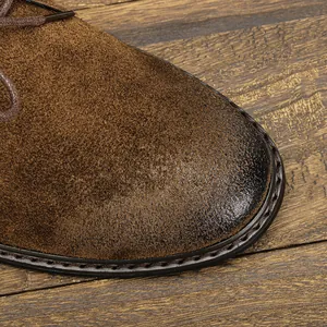 Détail de la botte de désert en daim marron rétro avec bout poli et coutures