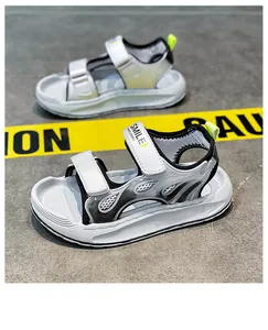Detailed macro shot of boys' white and black sports sandals with breathable velcro straps.