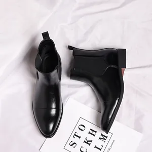 Draufsicht auf schwarze Chelsea-Boots für Herren mit spitzer Kappe auf weißem Tuch.