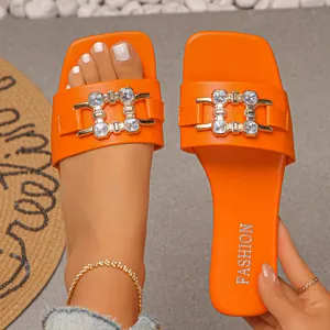 Vibrant orange flat slides with square toe and rhinestone buckle detail for women