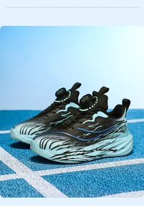 Close-up of cyan boys sports shoes with rotary buckle lacing and wave graphics.