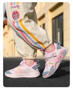 Gros plan de baskets roses et blanches pour enfants avec semelles souples en extérieur.