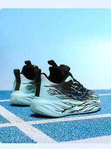 Close-up detail of boys' sports shoes with rotary buckle lacing on a blue running track