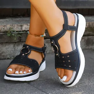 Macro shot of black platform sandals with decorative metal rings and laser-cut holes