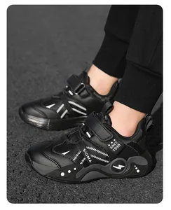 Détail latéral montrant des chaussures de sport en cuir noir pour enfants à semelle souple