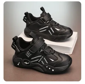 Détail latéral de chaussures de sport en cuir noir pour enfants à semelles souples