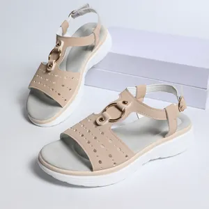 Detailed macro view of beige platform sandals with hollow-out design and gold metal ring