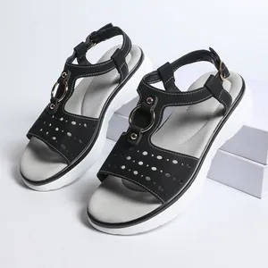 Detail of black platform sandals with hollow out design and metal ring accents.