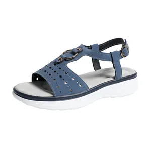Detail view of stylish blue women's sandals with hollow-out pattern and thick sole.