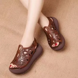 Vista detallada de sandalias de cuña en cuero marrón con diseño étnico y plataforma