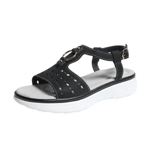 Side view of black T-strap thick sole sandals with perforated details and metal ring