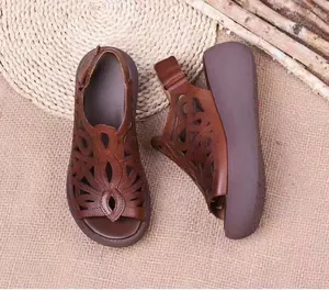 Detalle de sandalias de cuña marrón retro con plataforma y diseño calado