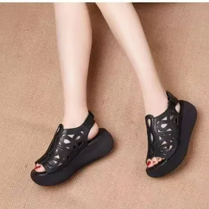Detalle de sandalias de plataforma negras retro con diseño floral calado con láser elegante