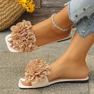 Detail shot of beige flat sandals for women featuring a large fabric flower accent