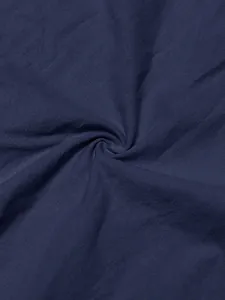 Detailed macro view of navy blue linen fabric with sand-washed wrinkled texture