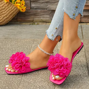 Close-up view of stylish pink flat sandals featuring oversized floral details