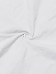 Close-up macro texture of white sand-washed linen fabric showing detailed weave and wrinkles.