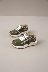 Vista detallada de zapatillas de moda para mujer en verde oliva y oro con cremallera