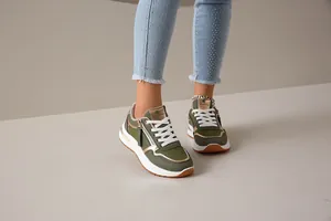 Primer plano de zapatillas deportivas de mujer en verde oliva con detalle de cremallera