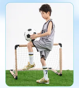 Children's white and gold TF soccer shoes for artificial grass training on a young boy