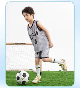Young boy playing soccer in white and gold TF turf soccer shoes on green grass field