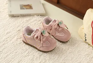 Detailed view of pink floral toddler girls sneakers with sweet strawberry charms on rug