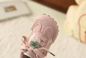 Detailed macro view of pink floral sneakers for girls with sweet strawberry bow accent