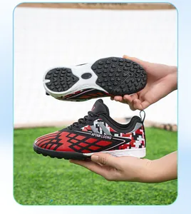Detail of kids' TF soccer cleats featuring non-slip rubber sole and red pixel pattern