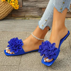 Vibrant blue flat slides featuring large 3D floral applique on a chic square toe sole.
