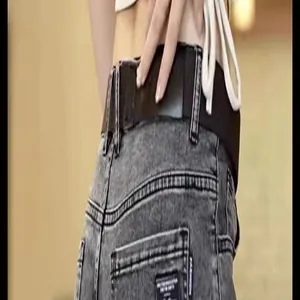Close-up detail of vintage washed grey slim fit denim jeans back pocket and waist