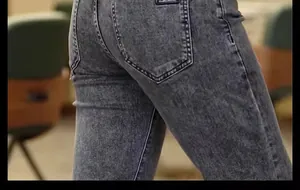Close-up of men's grey acid-wash slim fit jeans showing back pocket and denim texture