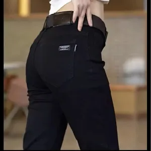 Detailed close-up view showing the back pocket design and hip fit of black slim casual jeans