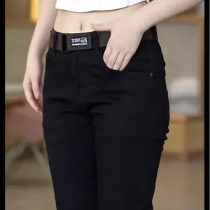 Detailed close-up of black slim fit denim jeans paired with a classic brown belt