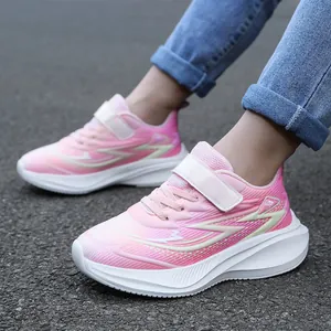 Detailansicht von rosa Kindersneakern mit dicken weißen Sohlen auf Asphaltboden.
