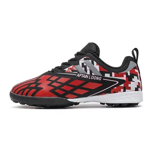 Red and black children's TF soccer shoes with pixel pattern for artificial grass use