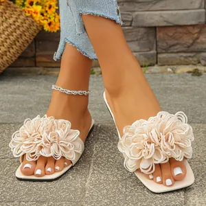 Elegant beige flat sandals with large fabric flower decoration for summer beach wear