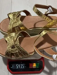 Women's gold platform sandals on a scale showing the lightweight design quality