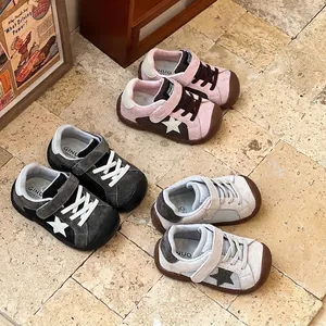 Detailed display of colorful children's star patch sneakers on a rustic tile background