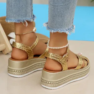 Detailed view of gold crocodile texture platform sandals with espadrille wedge sole
