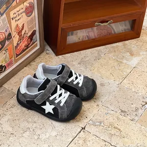 Detailed view of children's grey mesh casual sneakers with white star and strap.