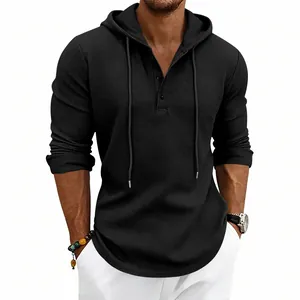 Macro view of men's black waffle knit Henley hoodie detailing the rich fabric texture