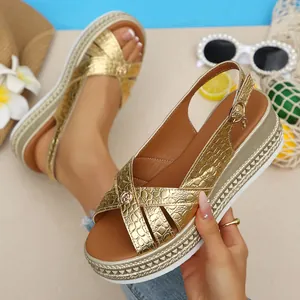 Close-up of golden croc-textured platform sandals with wedge heel and buckle strap