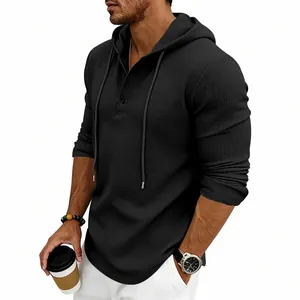 Detail of men's black waffle knit hooded Henley shirt with drawstring and buttons.