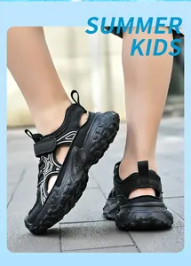 Detalle de sandalias de verano de malla transpirable negra para niños con suela blanda y gruesa