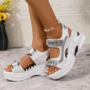 Dettaglio dei sandali con zeppa bianca da donna con plateau e cinturini Sport in strass